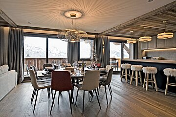 A dining room with a table and chairs and a bar