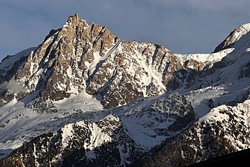 A snowy mountain covered in trees and rocks