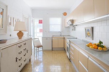 A kitchen with a bowl of fruit on the counter