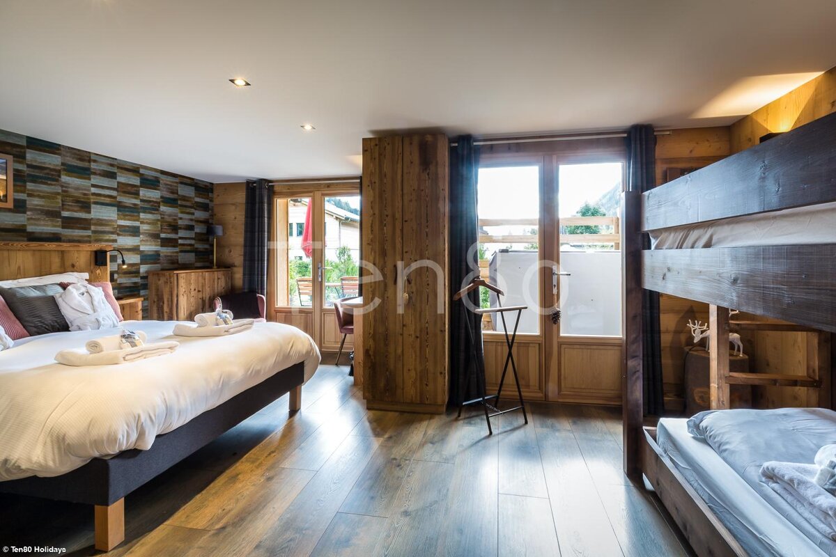 A hotel room with a bunk bed and two beds