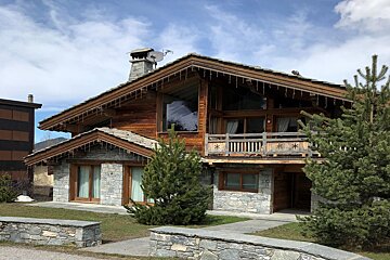 A large wooden house with a satellite dish on the roof