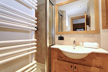 A bathroom with a sink a mirror and a towel rack
