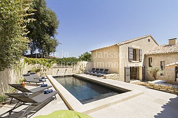 A large swimming pool in front of a house that says janssen immobilier