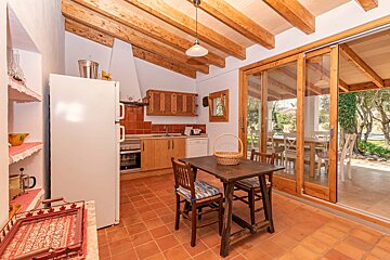 A kitchen with a table and chairs and a sliding glass door