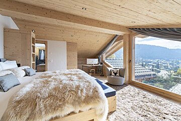 A bedroom with a large bed and a large window