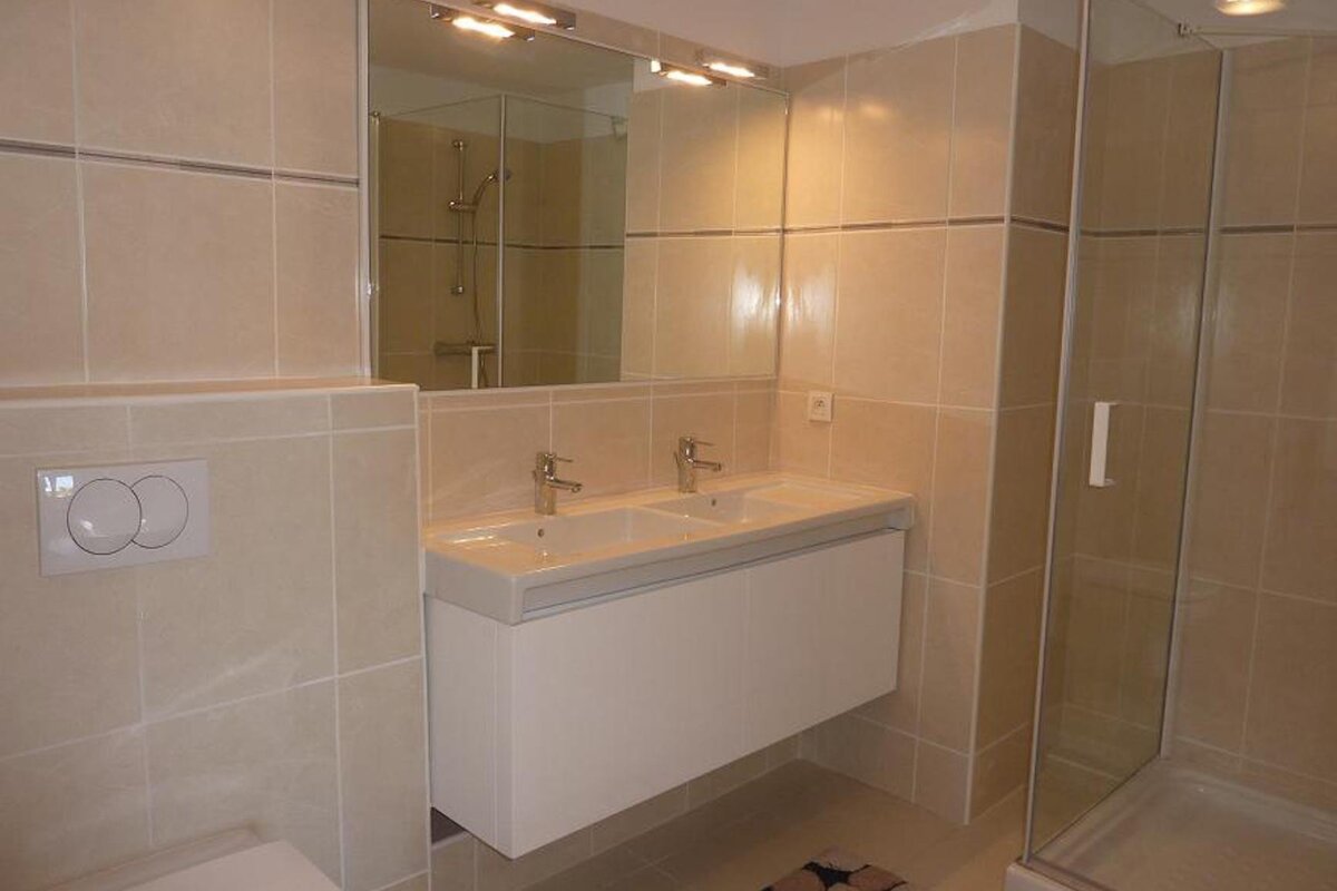 A bathroom with two sinks and a toilet