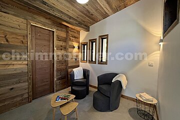 A room with chairs and a table with the website chximmobilier.com on the wall