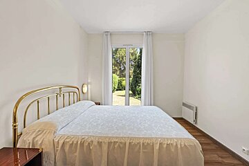 A bedroom with a large bed and a window