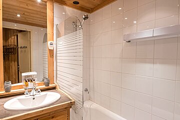 A bathroom with a sink a mirror and a shower
