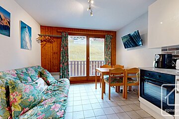 A living room with a couch a table and chairs and a flat screen tv