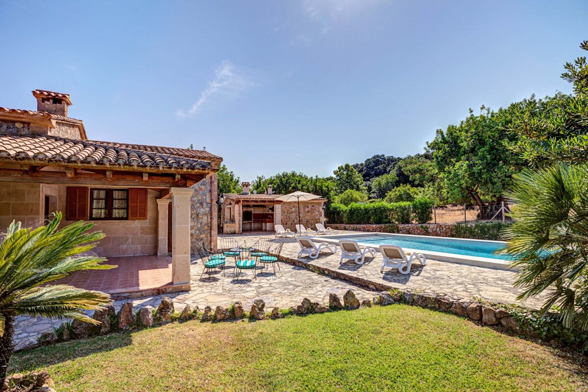 A house with a swimming pool and chairs in front of it