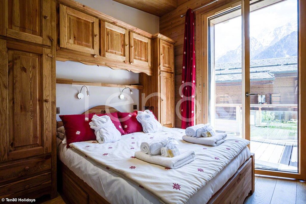 A bedroom with a bed and a window that says ten80 holiday