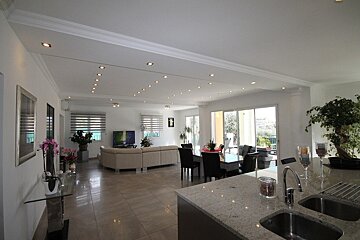 A kitchen with two sinks and a dining room in the background