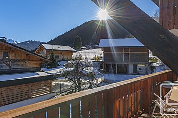 A balcony with a view of a snowy mountain and houses
