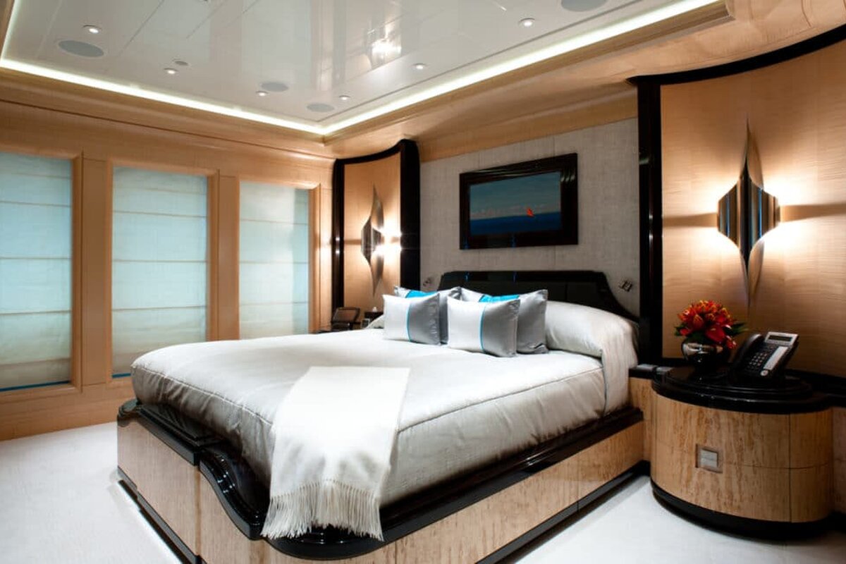 A bedroom with a painting on the wall above the bed