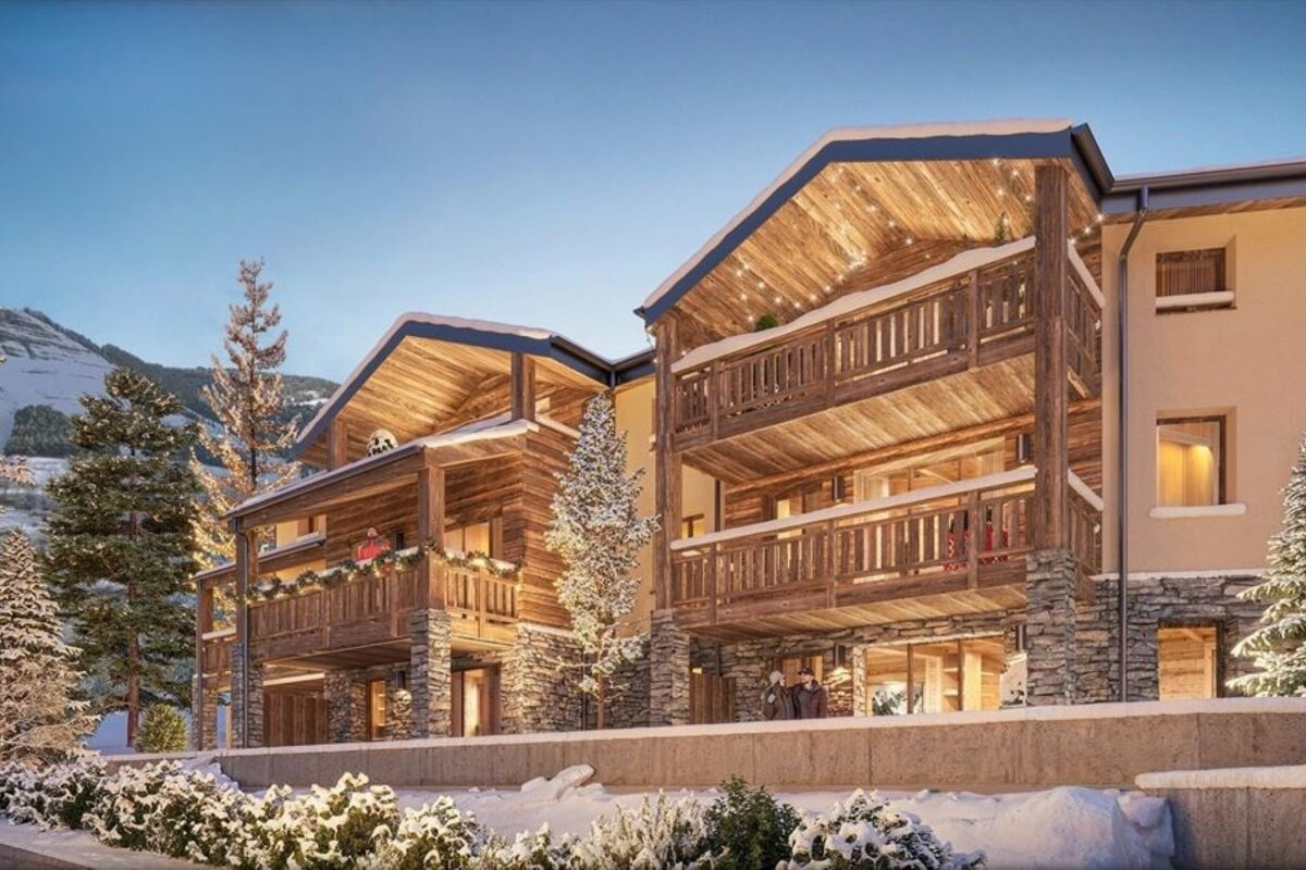 Cozy wooden alpine chalets glowing with warm lights in a snowy winter landscape.
