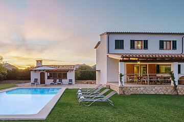 A large white house with a swimming pool in front of it