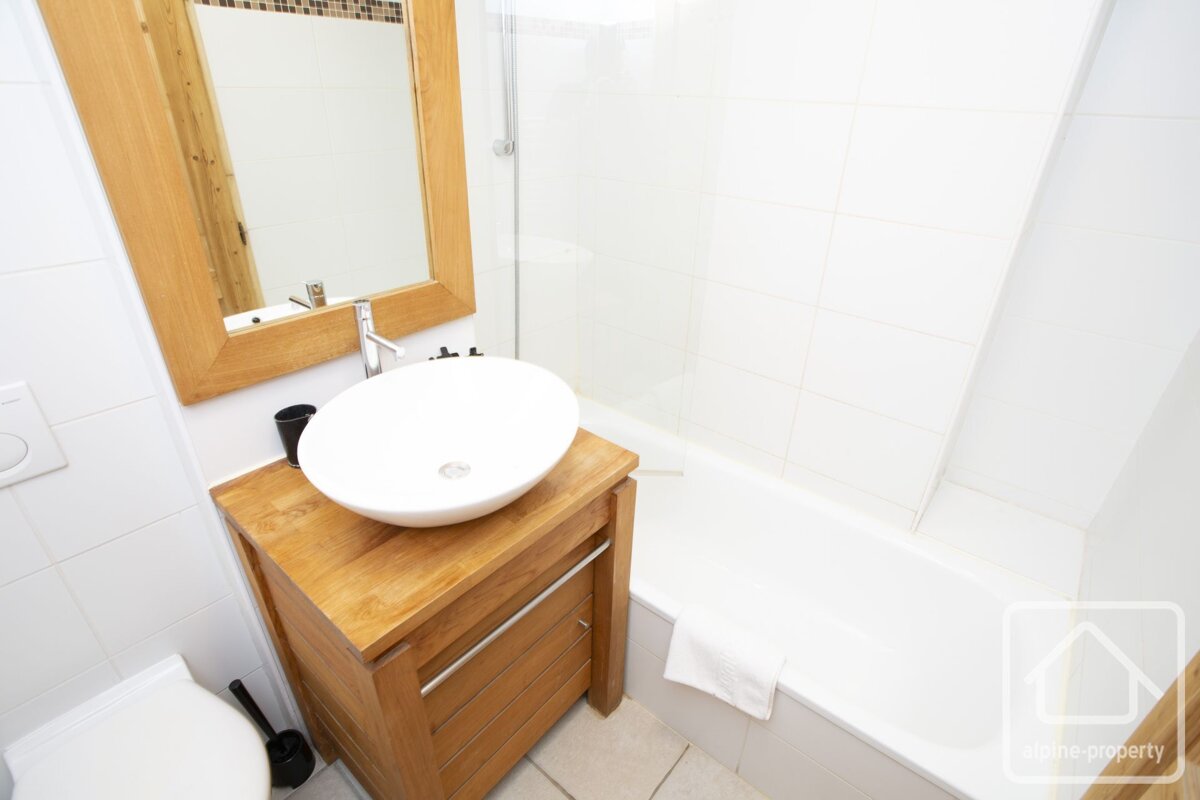 A bathroom with a sink a mirror and a bathtub