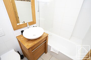 A bathroom with a sink a mirror and a bathtub