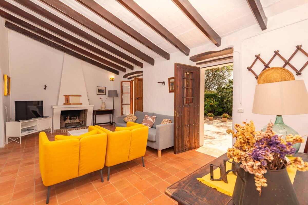 A living room with yellow couches and a fireplace