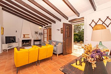 A living room with yellow couches and a fireplace