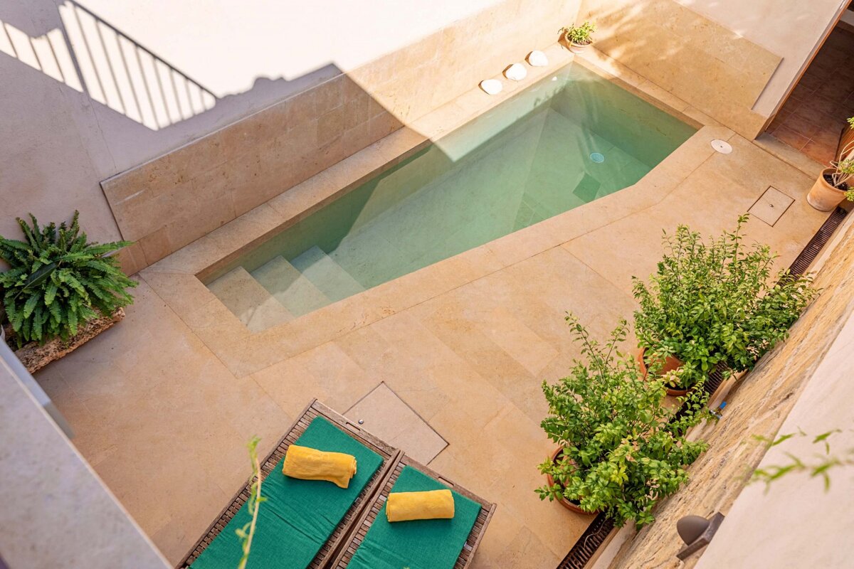 An aerial view of a swimming pool surrounded by chairs and plants