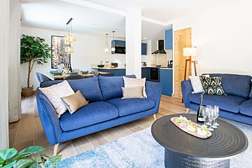 A living room with two blue couches and a coffee table