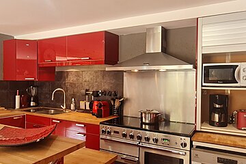 A kitchen with red cabinets and a stove that says ' electrolux ' on it