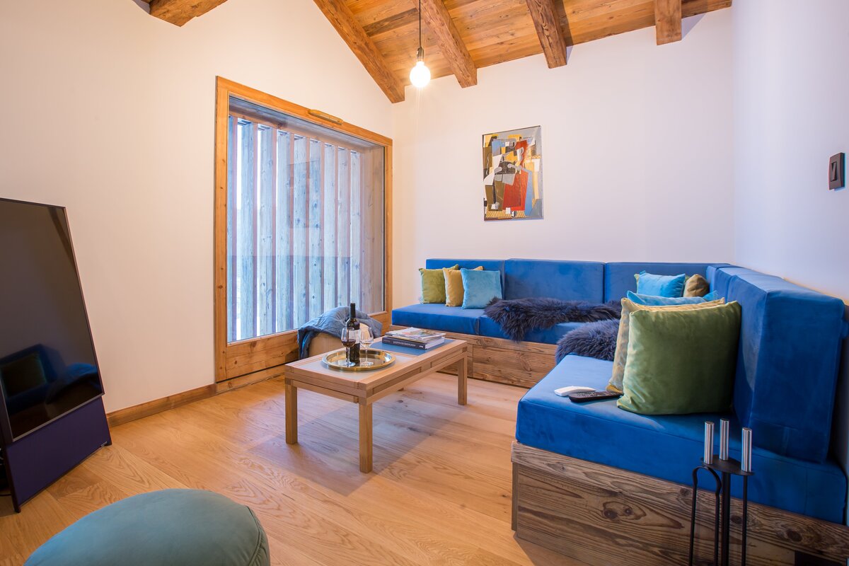 A living room with a blue couch and a wooden table