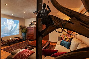 A living room with a projector screen that says tristan