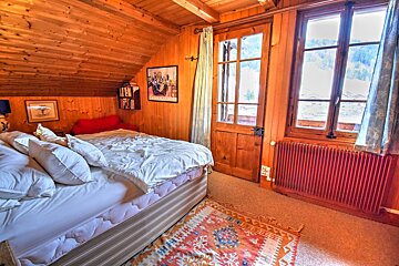 A bedroom with a bed and a picture on the wall