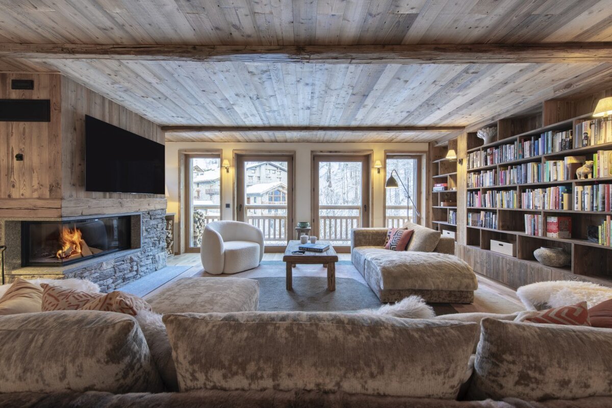 A living room with a fireplace and lots of books