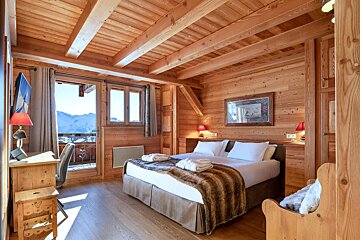 A wooden bedroom with a bed and a desk