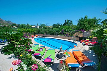 A swimming pool surrounded by lounge chairs and a fountain