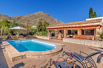 A house with a large swimming pool in front of it
