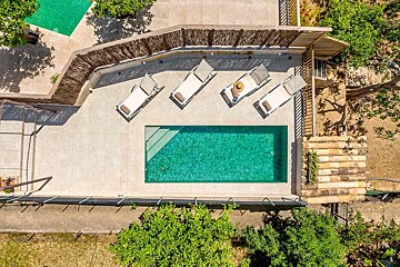 An aerial view of a swimming pool surrounded by lounge chairs