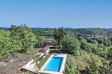 An aerial view of a large swimming pool surrounded by trees