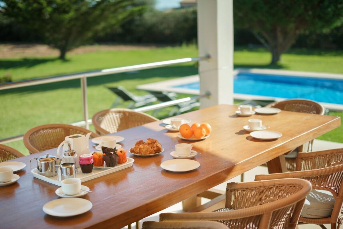 A patio with wicker furniture and a table and chairs