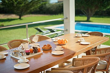 A patio with wicker furniture and a table and chairs