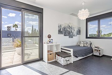 A bedroom with a sliding glass door and a bed