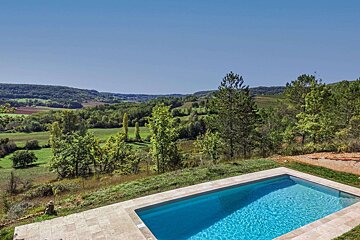A large swimming pool with a view of a valley