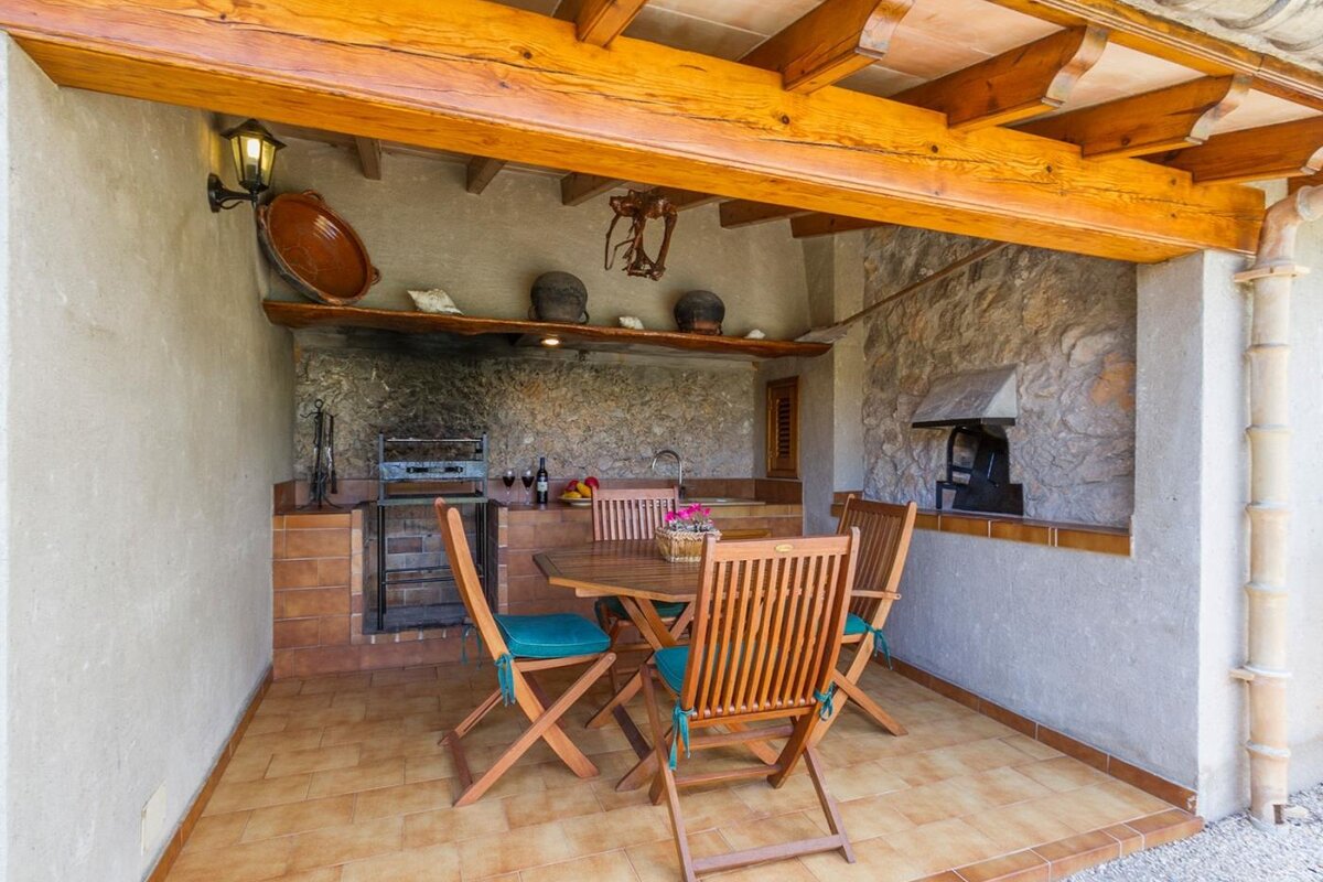 A wooden table and chairs under a wooden roof