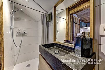A bathroom with a sink and shower by mountain base