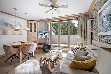 A living room with a ceiling fan and a painting of a polar bear on the wall