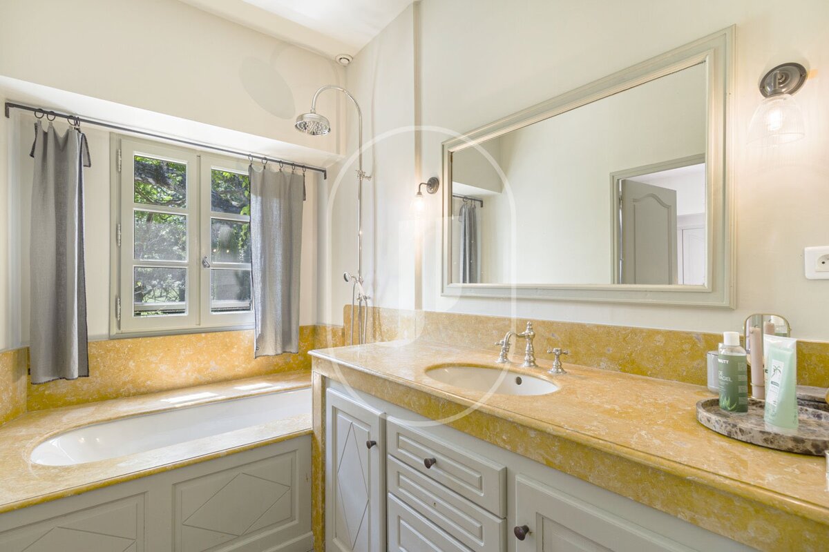 A bathroom with a sink a mirror and a window