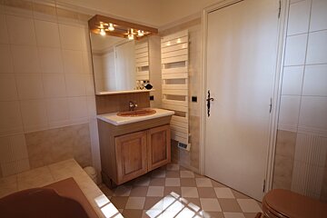 A bathroom with a sink a mirror and a towel rack