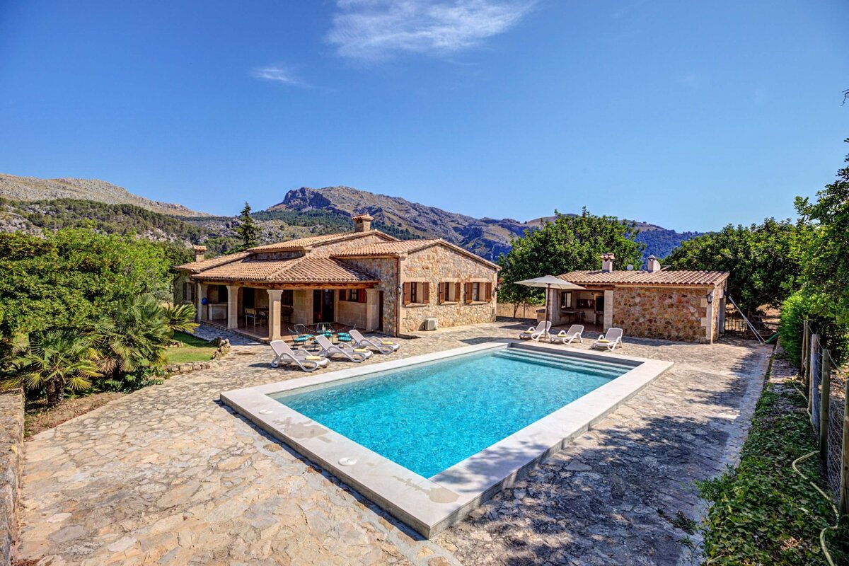 A house with a large swimming pool in front of it