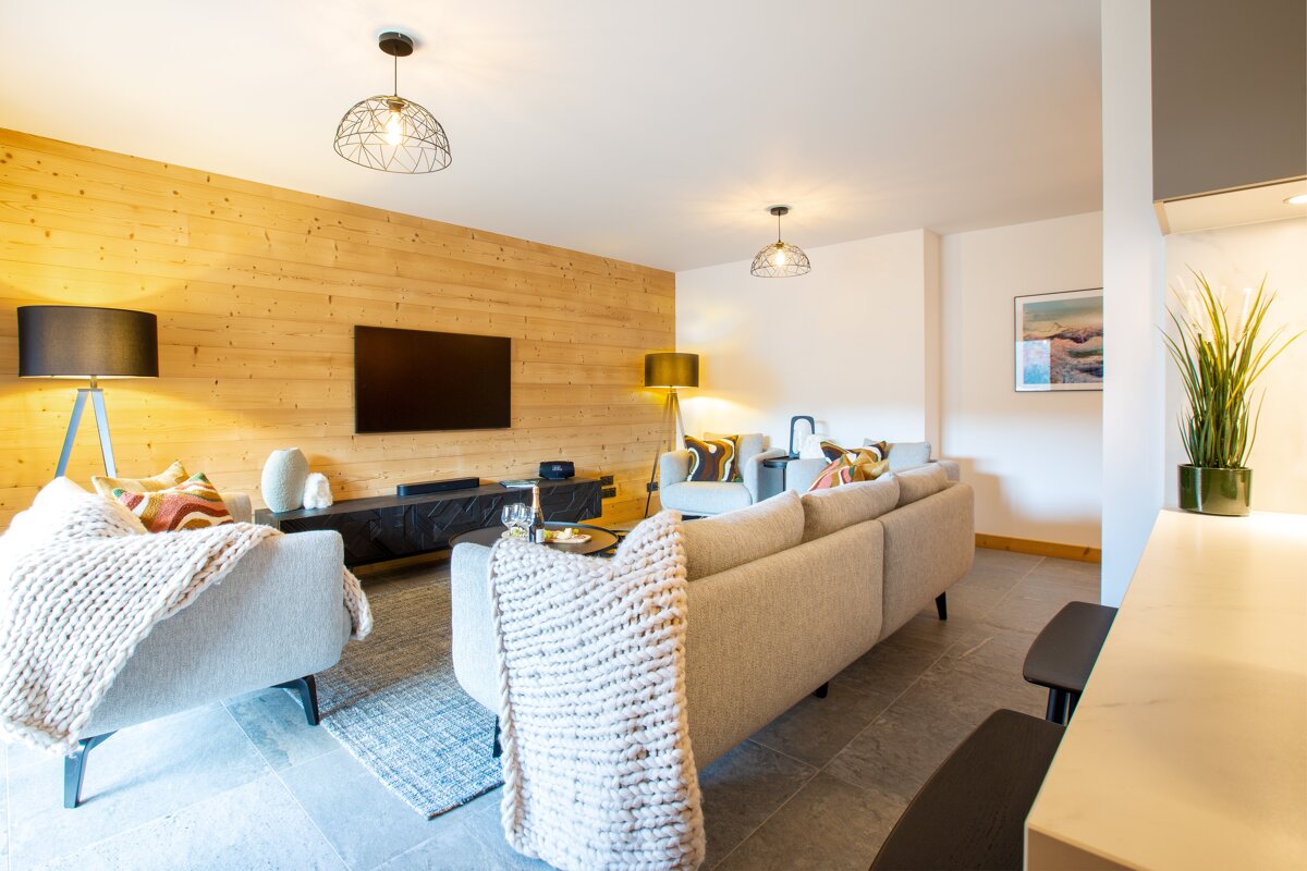 A living room with a couch a chair and a flat screen tv