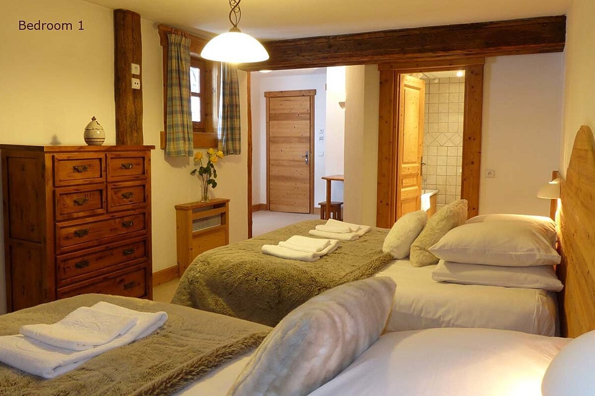 A bedroom with two beds and a dresser that says bedroom 1