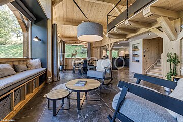 A living room with a couch and chairs and a table with a book on it